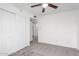 Bedroom featuring neutral carpeting, ceiling fan, and a large closet with sliding doors at 4032 W Reade Ave, Phoenix, AZ 85019