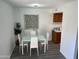 This dining room has a white table and chairs, wood look floors and a modern light fixture at 4032 W Reade Ave, Phoenix, AZ 85019