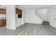 Bright living room showcasing wood-look floors, stairs, with partial kitchen view, and a side entry door at 4032 W Reade Ave, Phoenix, AZ 85019