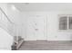 Bright living room featuring wood-look floors, staircase, a large front door, and a window with blinds at 4032 W Reade Ave, Phoenix, AZ 85019