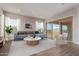 Bright living room featuring a blue sofa, neutral walls, and sliding glass doors to the backyard at 20755 W San Miguel Ave, Buckeye, AZ 85396