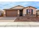 Attractive single-story home with a brown garage door and landscaped front yard at 19637 W Cartwright Ave, Buckeye, AZ 85396