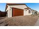 Two-car garage with brown door and brick driveway at 40532 W Wade Dr, Maricopa, AZ 85138