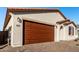 Two-car garage with brown door and brick driveway at 40532 W Wade Dr, Maricopa, AZ 85138