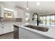 Kitchen island with sink, black faucet, and view of backyard at 40532 W Wade Dr, Maricopa, AZ 85138