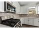 Stainless steel gas range and microwave in a modern kitchen at 40532 W Wade Dr, Maricopa, AZ 85138