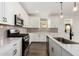 Modern kitchen with white cabinets and stainless steel appliances at 40532 W Wade Dr, Maricopa, AZ 85138