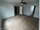 A simple bedroom features light blue walls with carpeted floors and a ceiling fan at 23671 W Wayland Dr, Buckeye, AZ 85326