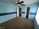 Bedroom featuring blue walls with a dark blue accent stripe, closet, and ceiling fan at 23671 W Wayland Dr, Buckeye, AZ 85326