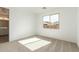 Bright, carpeted bedroom with a large window providing natural light, next to the bathroom at 40075 W Elm Dr, Maricopa, AZ 85138