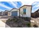 A charming single-story home with desert landscaping, rock beds, and a gray garage door at 40075 W Elm Dr, Maricopa, AZ 85138