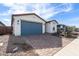 A well-manicured single-story home with a blue garage door and paver driveway at 40075 W Elm Dr, Maricopa, AZ 85138