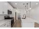 Modern kitchen with white cabinets, stainless steel appliances, an island, and stylish pendant lighting at 40075 W Elm Dr, Maricopa, AZ 85138