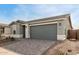 House exterior with gray siding and two-car garage at 40115 W Elm Dr, Maricopa, AZ 85138