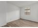 Well-lit bedroom featuring wood-look flooring and a window at 40090 W Elm Dr, Maricopa, AZ 85138