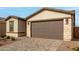 New construction home with a two-car garage and stone accents at 40090 W Elm Dr, Maricopa, AZ 85138