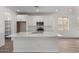 Modern kitchen featuring white cabinets, large island, and tile flooring at 40090 W Elm Dr, Maricopa, AZ 85138