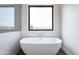 Bright bathroom showcasing a modern soaking tub beneath a picture window with dark wood flooring at 9626 E Bunny Ear Ln, Gold Canyon, AZ 85118