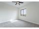 Empty bedroom featuring carpet flooring, a ceiling fan, and a window with a desert view at 9626 E Bunny Ear Ln, Gold Canyon, AZ 85118