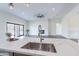 Modern kitchen island with quartz countertops, sink, and a view of the open-concept living space at 9626 E Bunny Ear Ln, Gold Canyon, AZ 85118