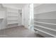 Walk-in closet featuring carpet flooring and white shelving, with a door to the shower at 9626 E Bunny Ear Ln, Gold Canyon, AZ 85118