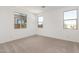 Bright bedroom featuring neutral carpet and large windows at 40500 W Wade Dr, Maricopa, AZ 85138