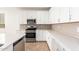 White kitchen with stainless steel appliances and subway tile backsplash at 40500 W Wade Dr, Maricopa, AZ 85138