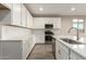 Modern kitchen featuring white cabinets, quartz countertops, and stainless steel appliances at 21641 N Daniel Dr, Maricopa, AZ 85138