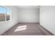 A bright, carpeted bedroom featuring a large window for natural light and a spacious interior at 680 W Crowned Dove Trl, Casa Grande, AZ 85122