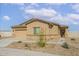 Tan single-story home featuring a two-car garage and neutral desert landscaping at 680 W Crowned Dove Trl, Casa Grande, AZ 85122