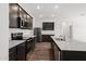Modern kitchen featuring granite countertops, stainless appliances, and dark wood cabinets at 680 W Crowned Dove Trl, Casa Grande, AZ 85122