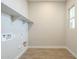 Bright laundry room with tile flooring, built-in shelving, and window at 20277 W Mulberry Dr, Buckeye, AZ 85396