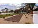Backyard featuring a bocce ball court, mature trees, and a lush green lawn with desert landscaping at 4350 N Jokake Dr, Scottsdale, AZ 85251