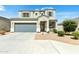 Two-story house with gray siding, a gray garage door, and landscaping at 10606 S 52Nd Ln, Laveen, AZ 85339