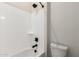 Bright bathroom with a shower featuring a white surround and black fixtures at 20262 W Hollyhock St, Buckeye, AZ 85396