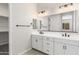 A modern bathroom with dual sinks, white cabinets, and a large mirror at 20262 W Hollyhock St, Buckeye, AZ 85396