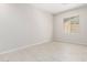 Bedroom with light colored tile flooring and neutral colored walls with a view of the outside from the window at 20262 W Hollyhock St, Buckeye, AZ 85396
