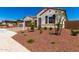 Well-maintained single-story home featuring desert landscaping, a brick driveway, and a two-car garage at 20262 W Hollyhock St, Buckeye, AZ 85396