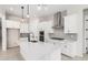 Modern kitchen with white cabinets, island sink, stainless steel appliances, and stylish pendant lighting at 20262 W Hollyhock St, Buckeye, AZ 85396