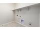 The Laundry Room has tile floors, neutral colors, and built in shelving at 20262 W Hollyhock St, Buckeye, AZ 85396