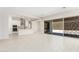 Spacious living room with tile floors, open layout, and seamless transition to modern kitchen and outdoor patio at 20262 W Hollyhock St, Buckeye, AZ 85396