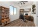Bright home office featuring wood floors, shelving, a ceiling fan, and a desk with a leather chair at 31730 N 169Th Ave, Surprise, AZ 85387