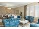 Open living and dining area with teal sofas and stone wall at 7054 E Ingram St, Mesa, AZ 85207
