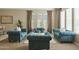 Spacious living room with teal sofas and large windows at 7054 E Ingram St, Mesa, AZ 85207