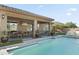 Inviting pool area with covered patio, lush landscaping, and outdoor seating at 7054 E Ingram St, Mesa, AZ 85207