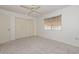 Bright bedroom featuring neutral carpet, a ceiling fan, and a large window at 10802 W Cameo Dr, Sun City, AZ 85351