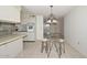 Open kitchen and dining area features tile flooring, breakfast bar, and bright lighting at 10802 W Cameo Dr, Sun City, AZ 85351