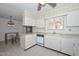 Bright kitchen with tile floors, white cabinets and stainless steel appliances and a ceiling fan at 10802 W Cameo Dr, Sun City, AZ 85351