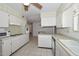 Bright kitchen with tile floors, white cabinets and stainless steel appliances at 10802 W Cameo Dr, Sun City, AZ 85351