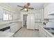 Bright kitchen with tile floors, white cabinets and stainless steel appliances and a ceiling fan at 10802 W Cameo Dr, Sun City, AZ 85351